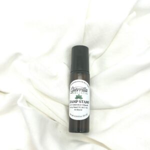 Cramp Stamp hormone support roller by Guerrilla Holistic on a white linen background, designed for PMS relief and lymphatic drainage