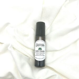 Pain Train roller by Guerrilla Holistic on a white linen background, designed for pain relief and lymphatic drainage